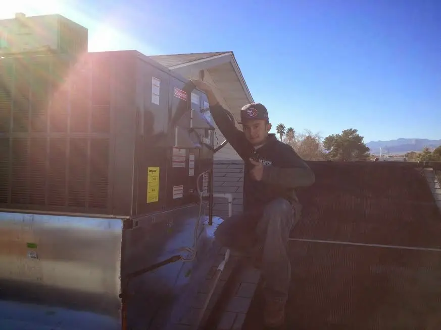 HVAC technician performing AC Tune-Up on a rooftop unit in Harwinton